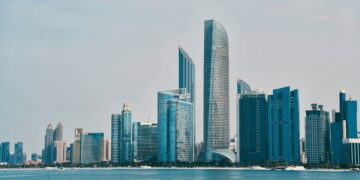 Abu Dhabi city skyline with a body of water in the foreground.