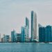 Abu Dhabi city skyline with a body of water in the foreground.
